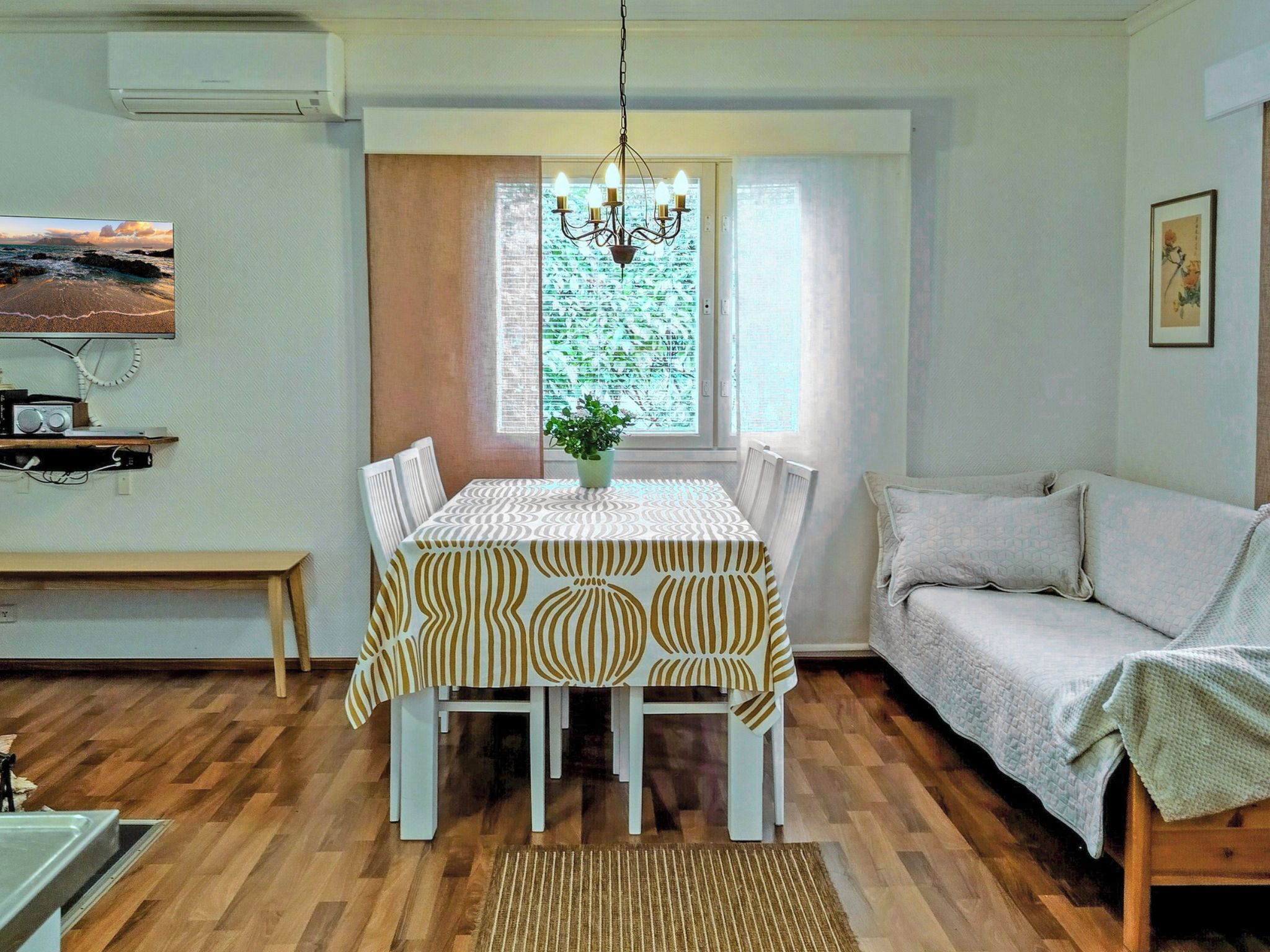 Un comedor con una mesa para cuatro, un sofá, un banco y una ventana con vistas.