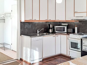 Una cocina compacta equipada con lavavajillas, microondas, tostadora y estufa.