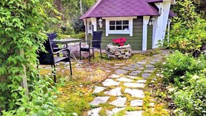 A small house with a stone pathway leading to a seating area with chairs. - Villa paasirinne b by Interhome (Toivakka)