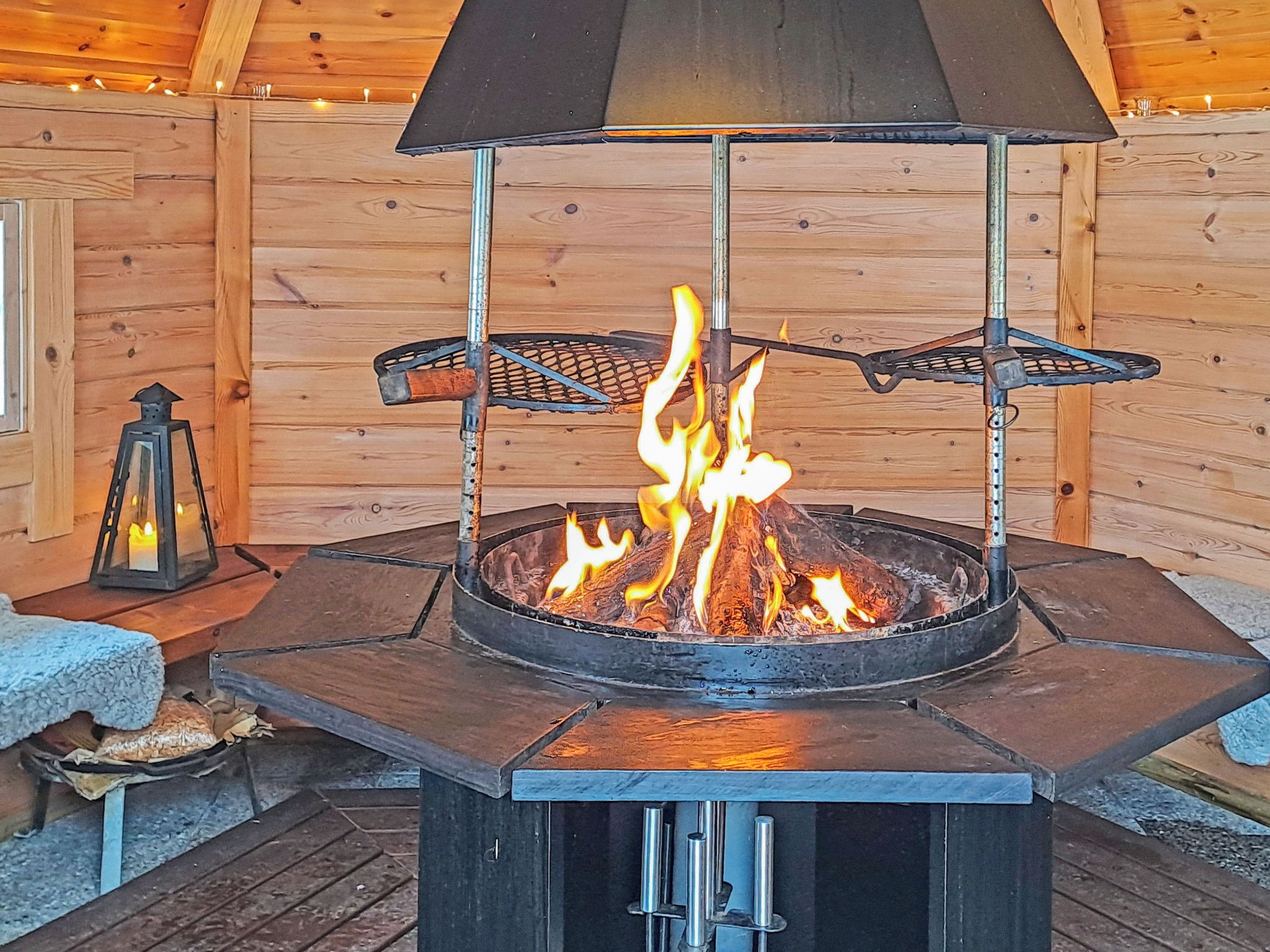 Un hogar al aire libre circular con una rejilla metálica y una chimenea negra.