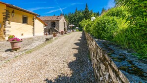A cobblestone street lined with stone buildings, a gravel path, and lush greenery. - Certina 4 by Interhome (Pontassieve)