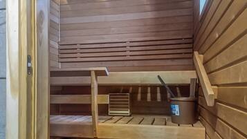 Una sauna con bancos de madera y un cubo y una cuchara.