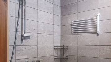A modern shower area with a handheld showerhead, a wall-mounted towel rack, and a corner shelf.