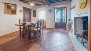 A dining area with a wooden table and chairs, a ceiling fan, and a tiled floor. - Casa di Nena by Interhome (Camaiore)