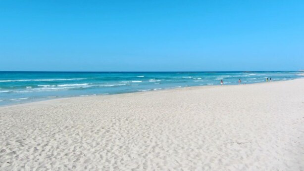 A wide sandy beach with clear blue water and a few people in the distance. - Tenuta Nucci by Interhome (Gallipoli)
