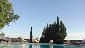 A swimming pool with lounge chairs and tall trees in the background. - Tenuta Nucci by Interhome (Gallipoli)