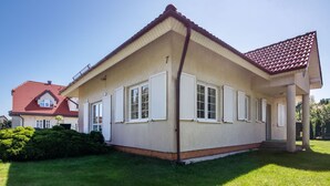 A two-story house with a red-tiled roof, white shutters, and a small front porch. - Mały dworek by Interhome (Leba)
