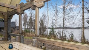 A wooden deck with a view of a lake and trees. - Mustikka by Interhome (Hämeenlinna)