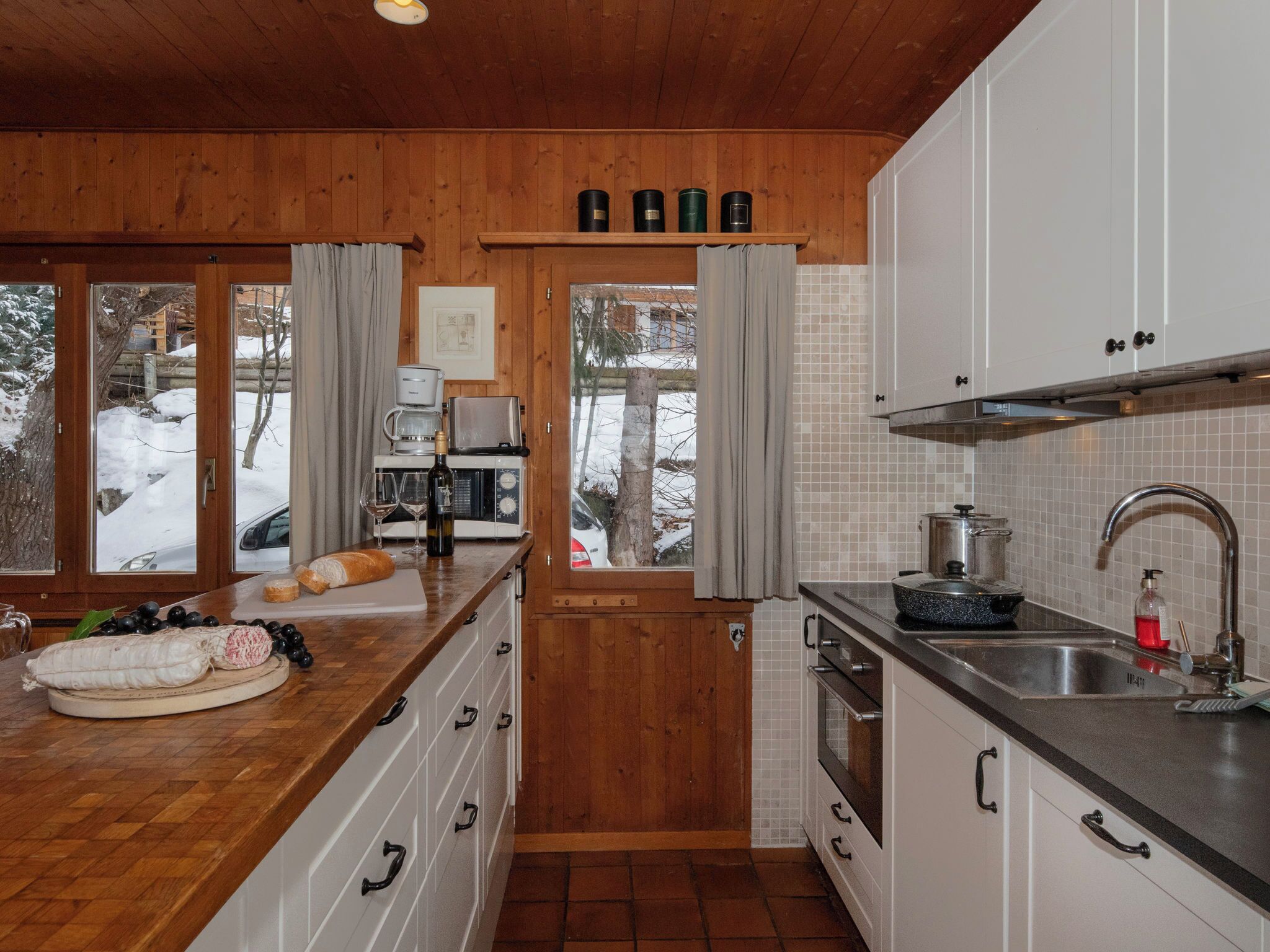 A wooden interior with a kitchen area, including a sink, stove, and cabinets.