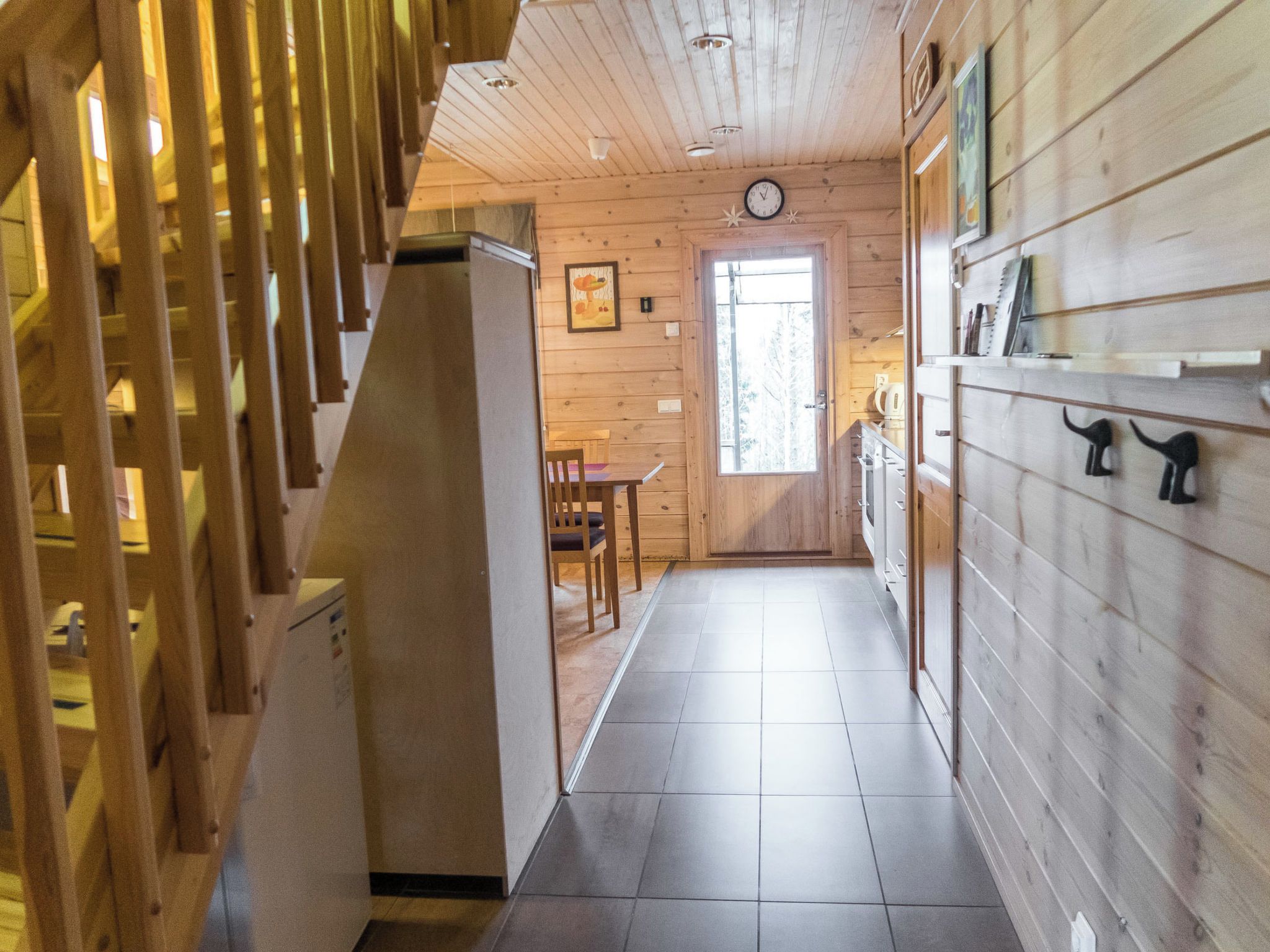 Un interior de madera con una escalera, un comedor y una cocina.