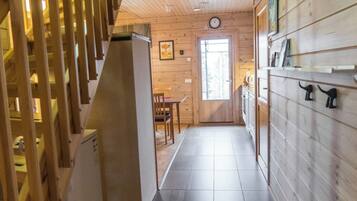 Un interior de madera con una escalera, un comedor y una cocina.