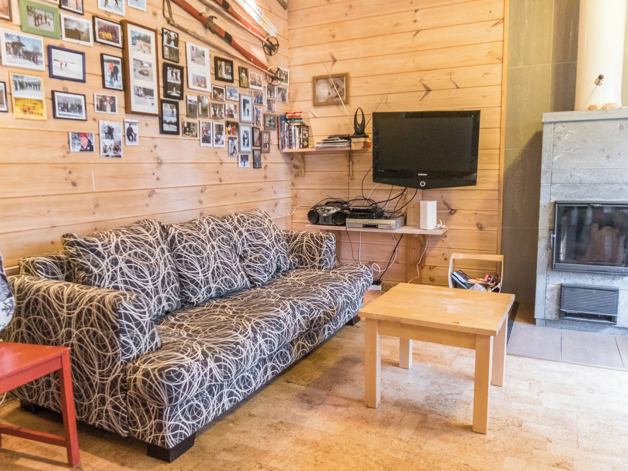 Una sala de estar acogedora con un sofá estampado, un televisor y una chimenea.
