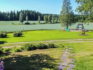 A park with a grassy area, a pond, and a swing set. - Virrin tila by Interhome (Sastamala)