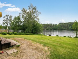 Una zona erbosa con un pontile di legno e un lago.