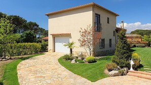 A two-story house with a stone driveway, a garage, and a well-maintained garden. - Vacation home Marina by Interhome (Vidreres)
