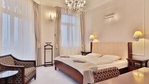 A hotel room with a large bed, two bedside tables, a chandelier, a desk, and a chair. - Sun Palace Wellness Hotel Marianske Lazne (Marianske Lazne)