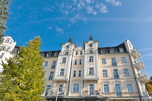 A multi-story building with a classic architectural style, featuring ornate balconies and a symmetrical facade. - Sun Palace Wellness Hotel Marianske Lazne (Marianske Lazne)