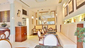 A hotel lobby with a reception desk, seating area, and a large mirror. - Sun Palace Wellness Hotel Marianske Lazne (Marianske Lazne)