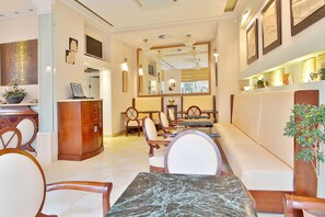 A hotel lobby with a reception desk, seating area, and a large mirror. - Sun Palace Wellness Hotel Marianske Lazne (Marianske Lazne)