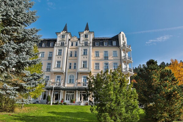 A large, multi-story building with a symmetrical facade, multiple balconies, and a central entrance with steps. - Sun Palace Wellness Hotel Marianske Lazne (Marianske Lazne)