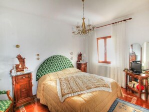Cozy retreat with a large bed, nightstand, dresser, and TV, set amidst a comfortable seating area.