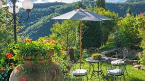 Un jardin avec une table et des chaises, un lampadaire et un grand parasol.