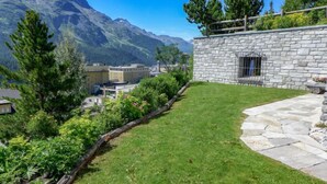 A stone building with a stone pathway leading to a wooden deck. - Chesa Sül Muot by Interhome (St. Moritz)
