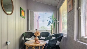 A room with wicker chairs, a round table, a vase with dried flowers, a potted plant, and a window with blinds. - Apartment Rekowo by Interhome (Rekowo)