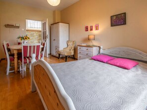 A bedroom with a bed, a desk with a chair, a wardrobe, and a nightstand with a lamp. - Apartment Rekowo by Interhome (Rekowo)