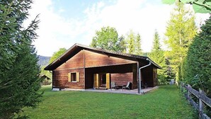 Une cabane en bois avec une véranda et deux chaises.