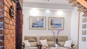 A living room with two sofas, a coffee table, and two paintings on the wall.