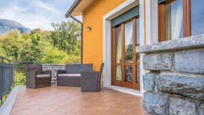 A patio with outdoor furniture, a stone wall, and a view of greenery and mountains. - La Casa al Monte by Interhome (Camaiore)