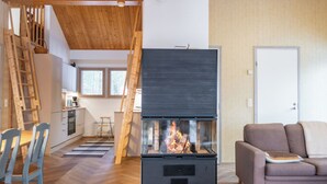 A modern living room with a fireplace, wooden furniture, and a staircase. - Keskikallio, nuasjärvi by Interhome (Sotkamo)