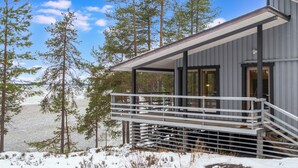 A modern cabin with a balcony overlooking a snowy landscape and a body of water. - Keskikallio, nuasjärvi by Interhome (Sotkamo)
