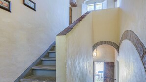Eine Treppe mit Steinverkleidung, die zu einem Außenbereich mit Tisch und Stühlen führt.