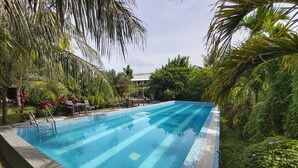 Una piscina al aire libre, sombrillas, tumbonas