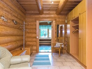 A log cabin interior with a wooden bench, a chair, a coat rack, and a wardrobe. - Honkalinna by Interhome (Mikkeli)