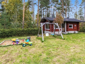 A cabin with a swing set and a play area with toys. - Honkalinna by Interhome (Mikkeli)