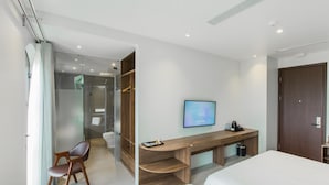 A modern hotel room with a bed, a desk with a computer, a chair, and a TV. - The Twin Hotel (Bai Chay)