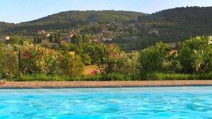 Ein Pool mit Blick auf ein Hügel-Dorf.