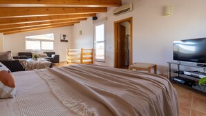 A spacious room with a large bed, a TV, and a balcony. - Vacation home Sally by Interhome (Deltebre)
