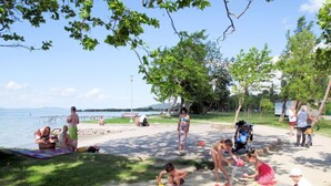 A beach scene with people relaxing and children playing. - Vacation home Peach by Interhome (Balatonfenyves)