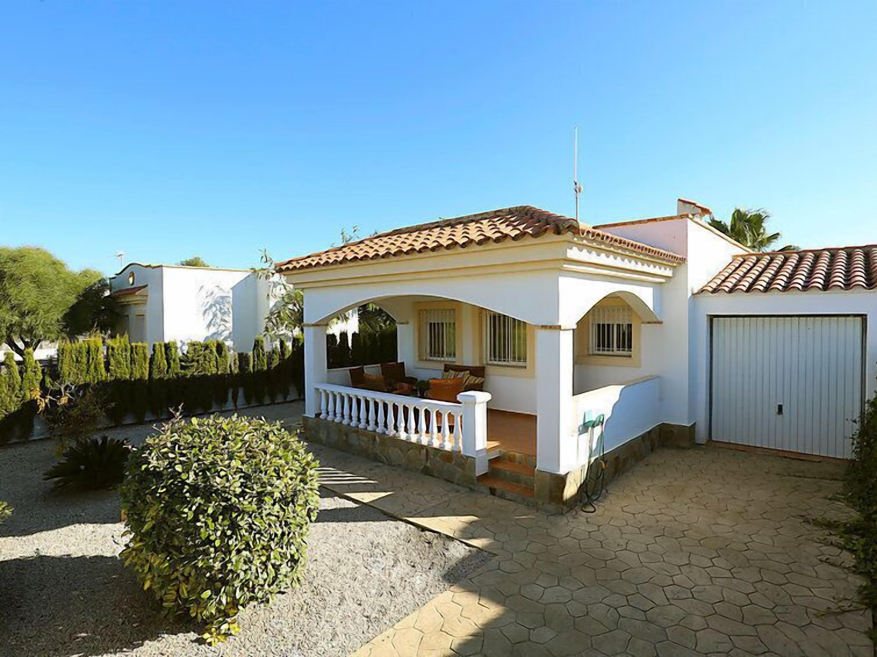 A two-story house with a tiled roof, a covered porch, and a garage.