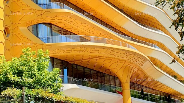 Um edifício com fachada curva singular e várias varandas.