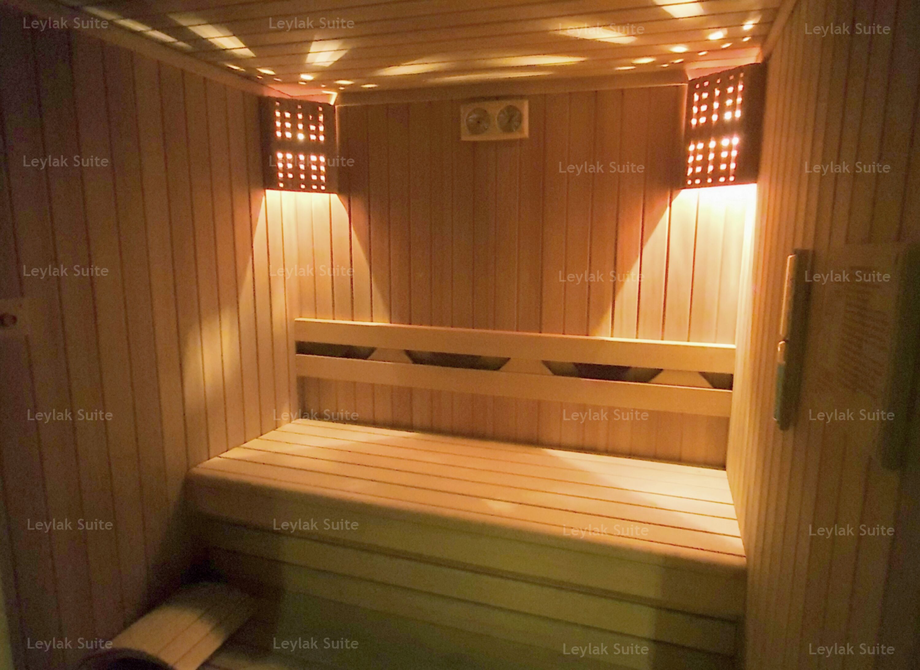 A sauna room with wooden benches and a bench at the bottom.