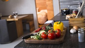 A kitchen counter with fresh vegetables, a cutting board, and a knife. - Superior Alpine by Interhome (Laax)