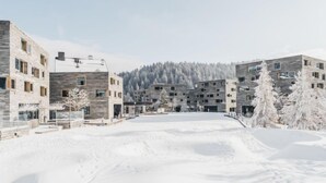 A modern building complex with multiple floors and a central courtyard. - Superior Alpine by Interhome (Laax)