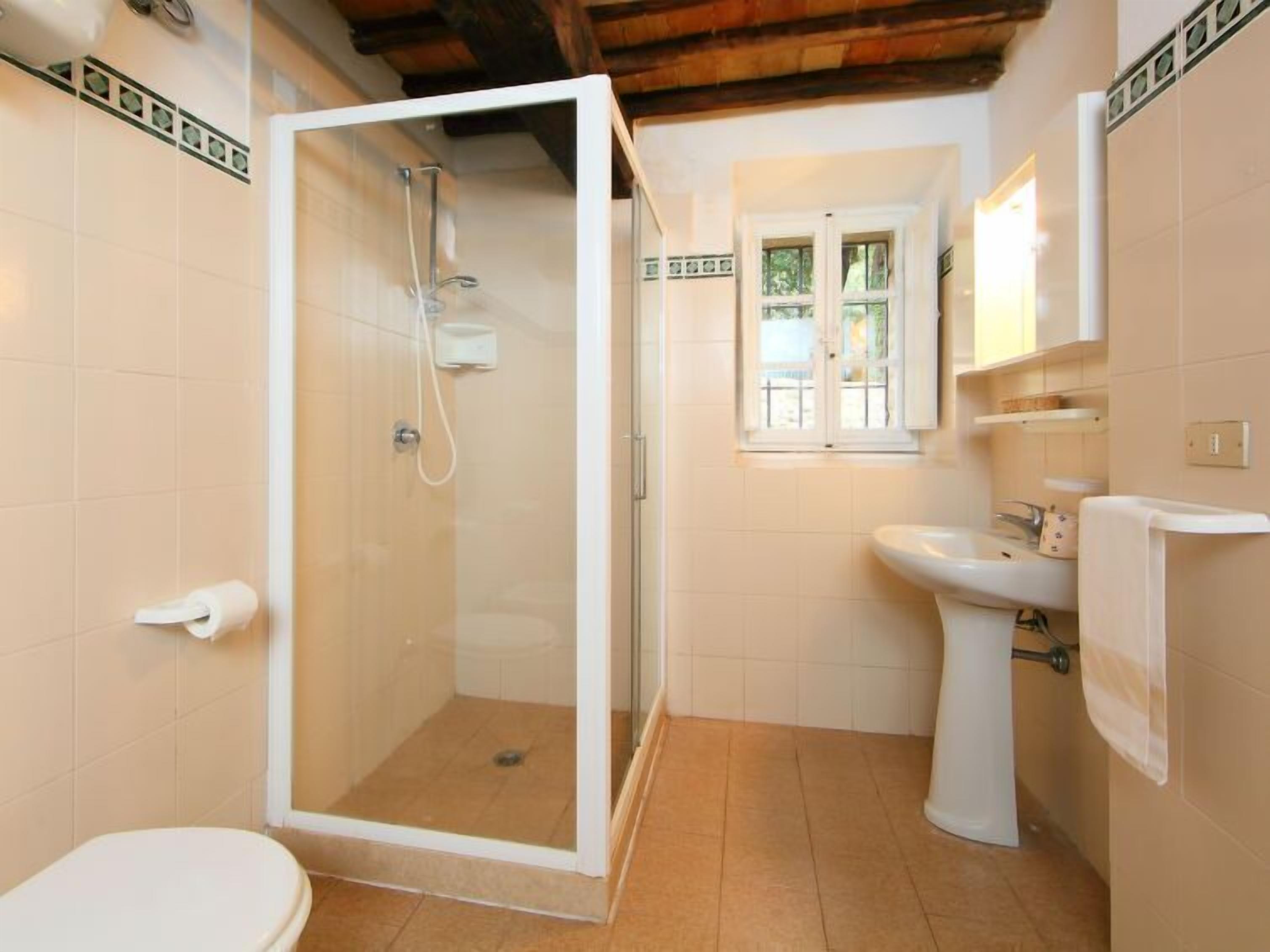 Une salle de bain avec douche, toilettes et lavabo.