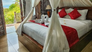 A bedroom with a canopy bed, red pillows, and a view of greenery outside. - Hotra Hill Cottage (Penida Island)