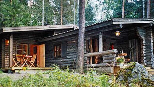 A rustic log cabin with a porch and outdoor seating area. - Kultaranta by Interhome (Asikkala)